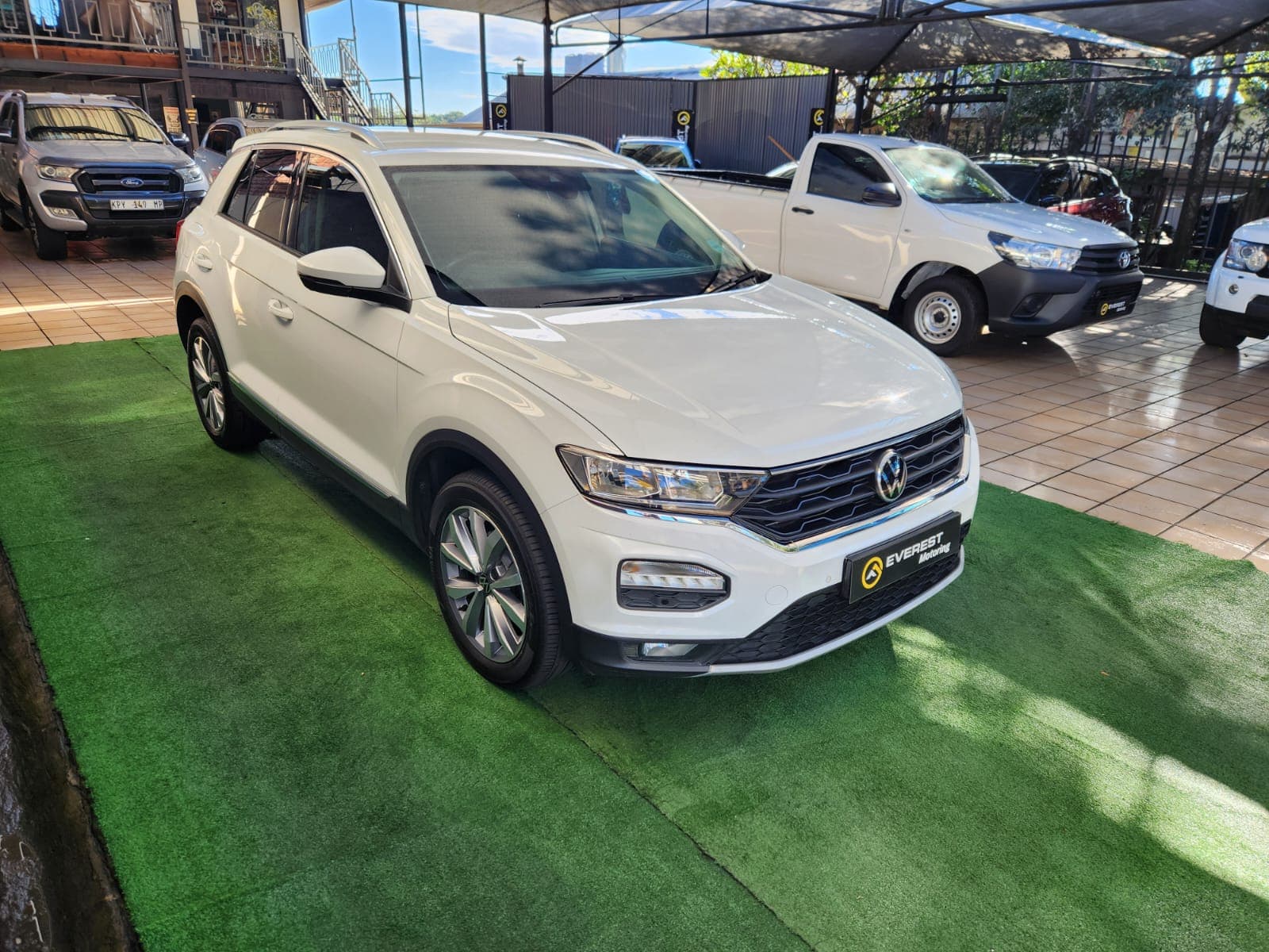 White 2021 Volkswagen T-Roc 1.4 TSI Design Auto, front right three-quarter exterior view at dealership.