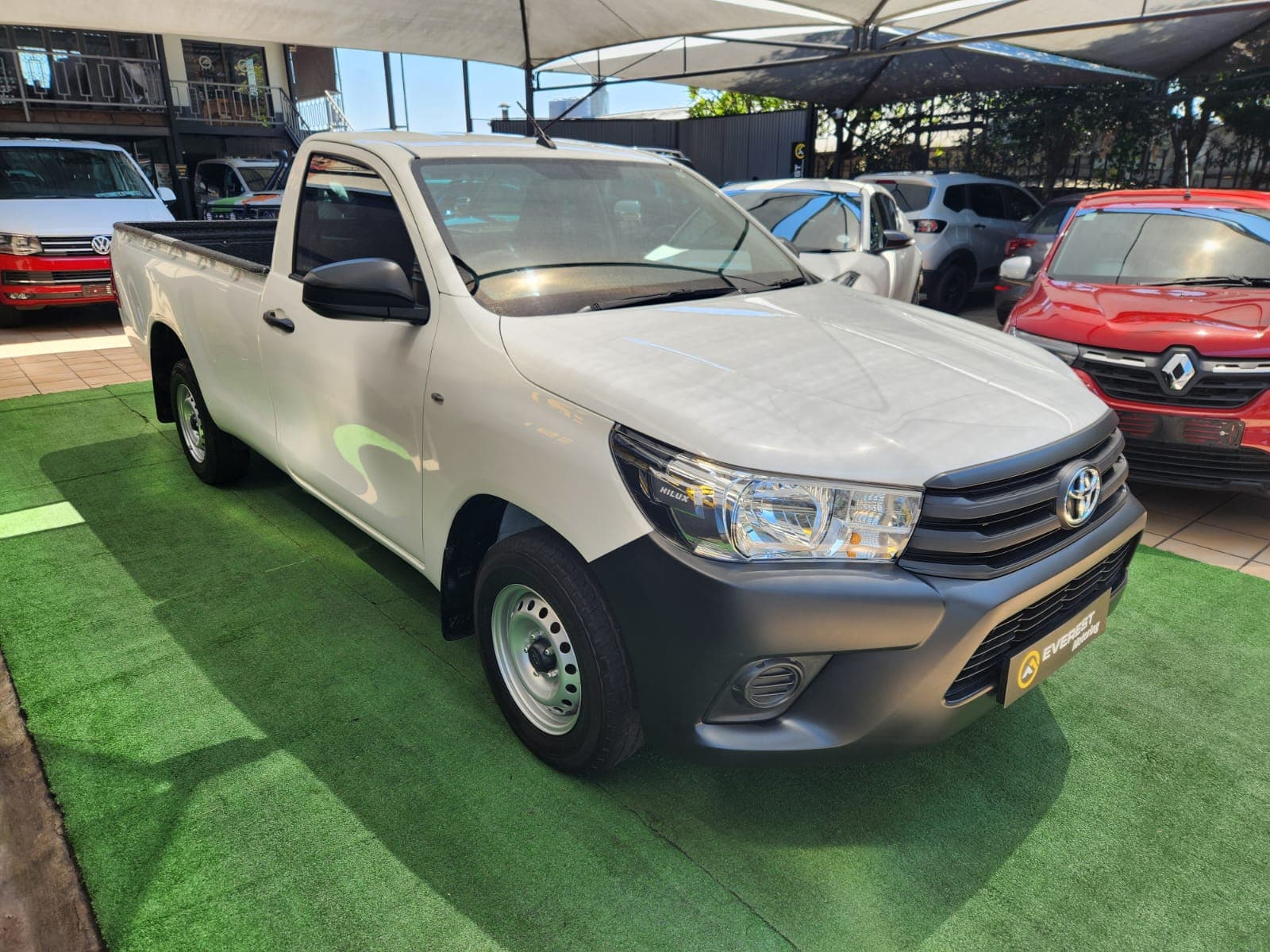White 2025 Toyota Hilux 2.4 GD Single-Cab, front three-quarter exterior view, showing front grille and wheel.