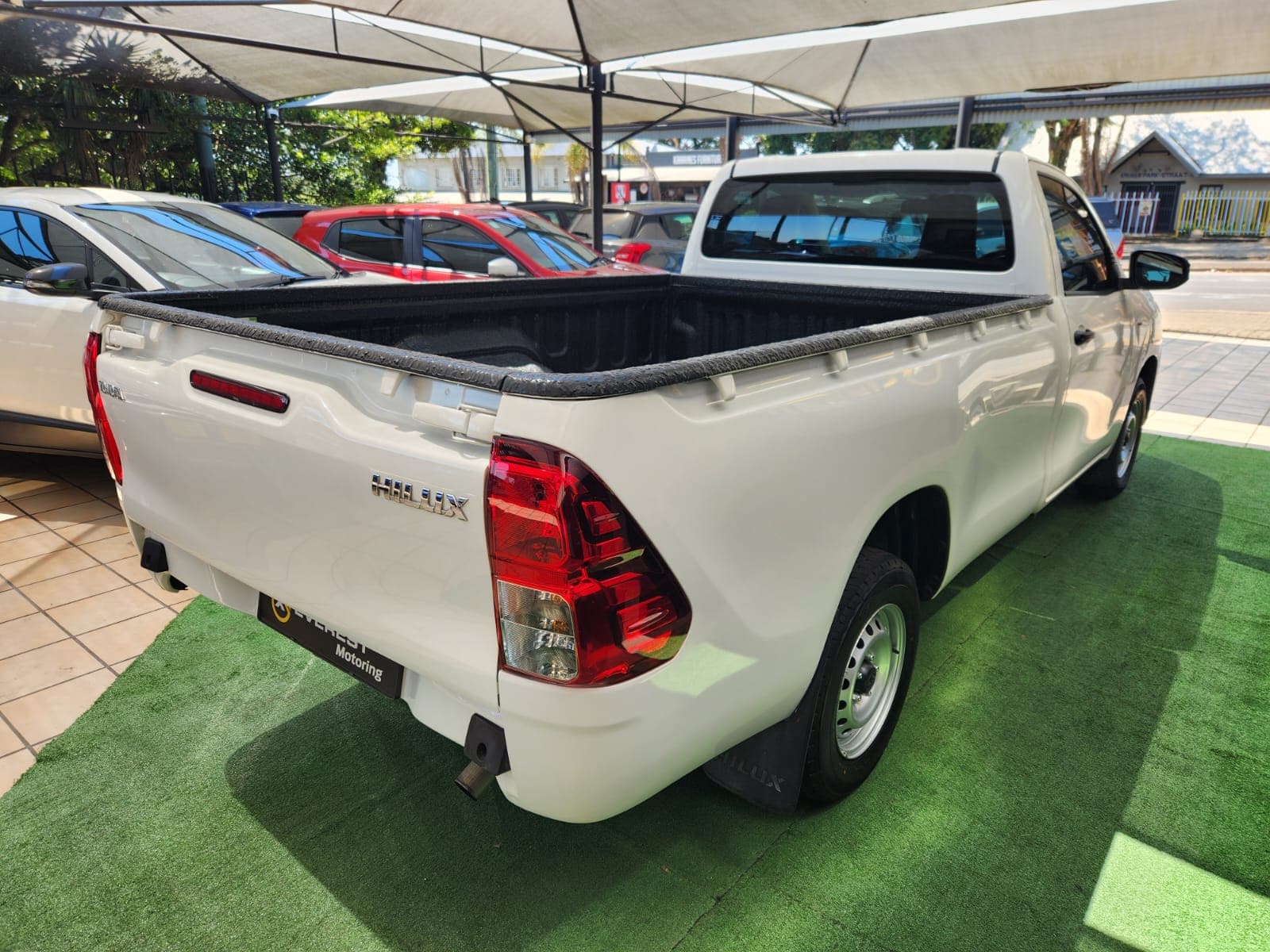 Rear exterior view of the white 2025 Toyota Hilux 2.4 GD Single-Cab, showcasing the bakkie's tailgate.